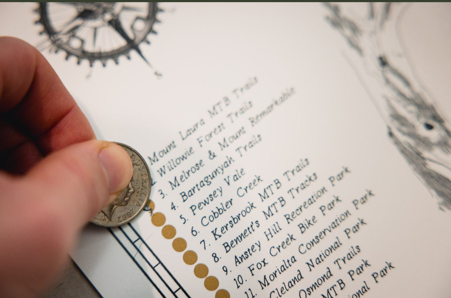 Hand holding a coin over a map with numbered locations